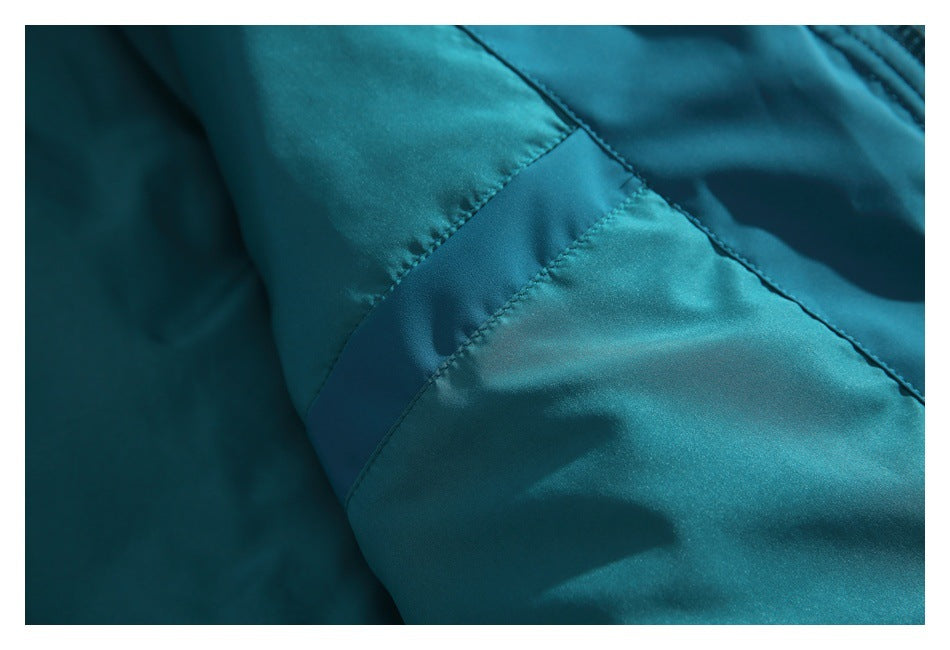 Close-up of a stitched seam and panel on the teal jacket.