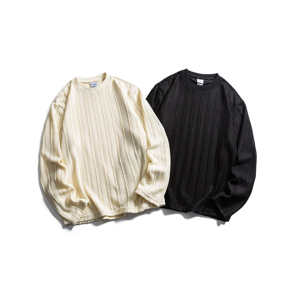 Front flat lay of two long-sleeve crew-neck tops with vertical ribbed texture, in ivory and black.