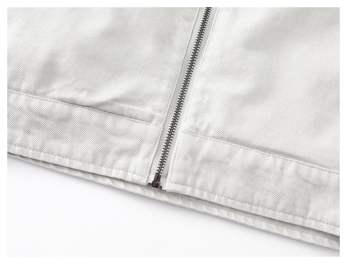 Close-up of the off-white jacket hem and lower end of its metal front zipper.