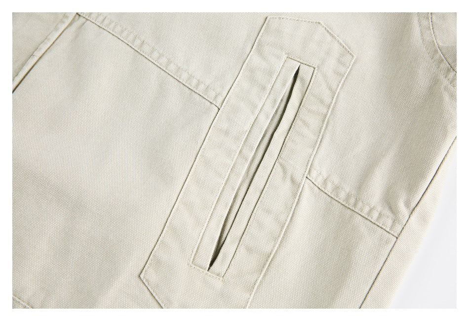 Close-up of a cream jacket's long welt pocket and surrounding panel stitching.