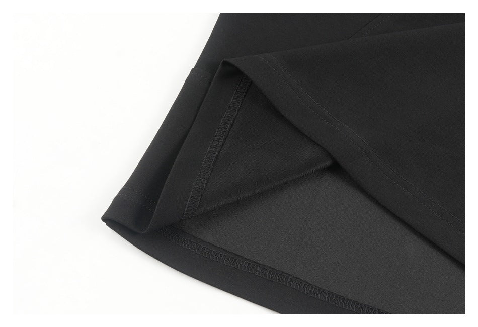 Black garment hem turned back to show the interior overlock stitching.