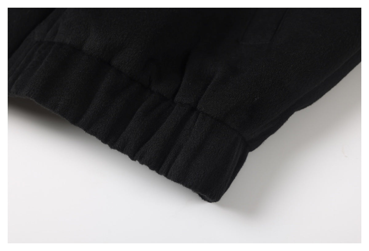Close-up of the gathered, banded hem on a black jacket.