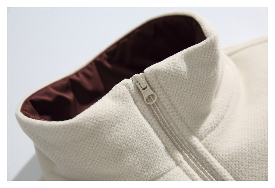Close-up of a cream stand collar with dark brown lining and a light-colored zipper.