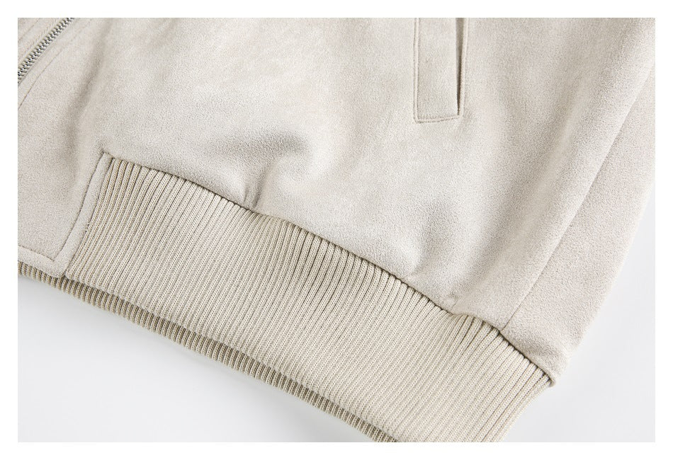 Close-up of a light beige jacket hem with a wide ribbed band and welt pocket.