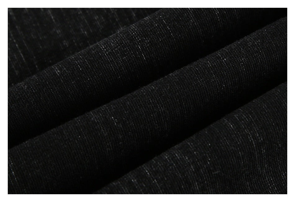 Close-up of black fabric folded into soft ridges, showing its fine knit texture.
