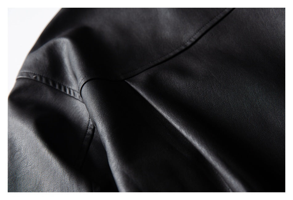 Close-up of black garment fabric with curved stitched seams and a smooth, slightly reflective surface.