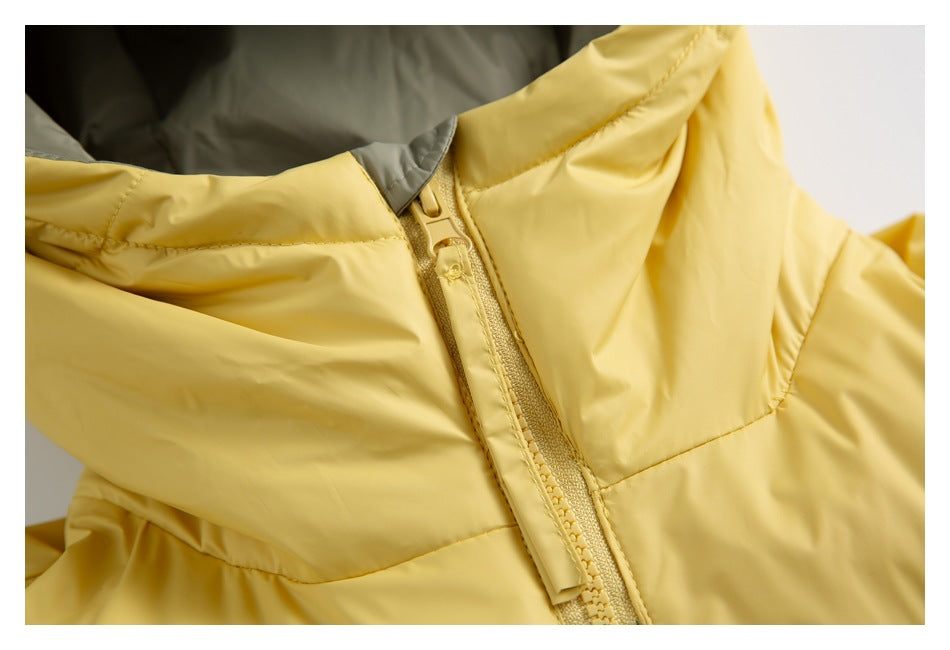 Close-up of the yellow jacket’s front zipper, zipper pull, and stitched panels.