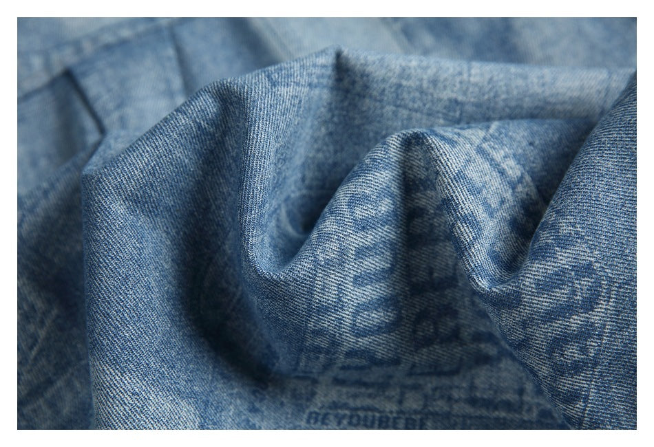 Close-up of gathered blue denim fabric showing its printed pattern and texture.