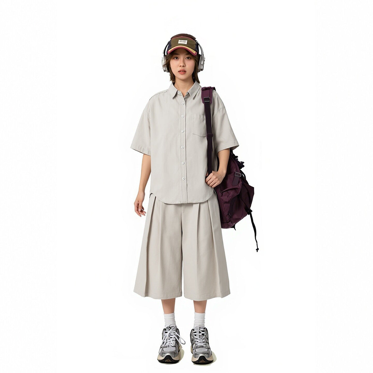 Model wearing a light gray oversized short-sleeve button-up shirt and matching wide cropped pants.