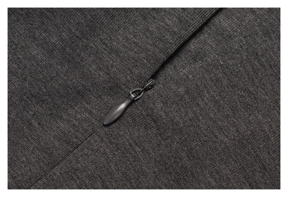 Close-up of a black zipper pull on charcoal knit fabric.