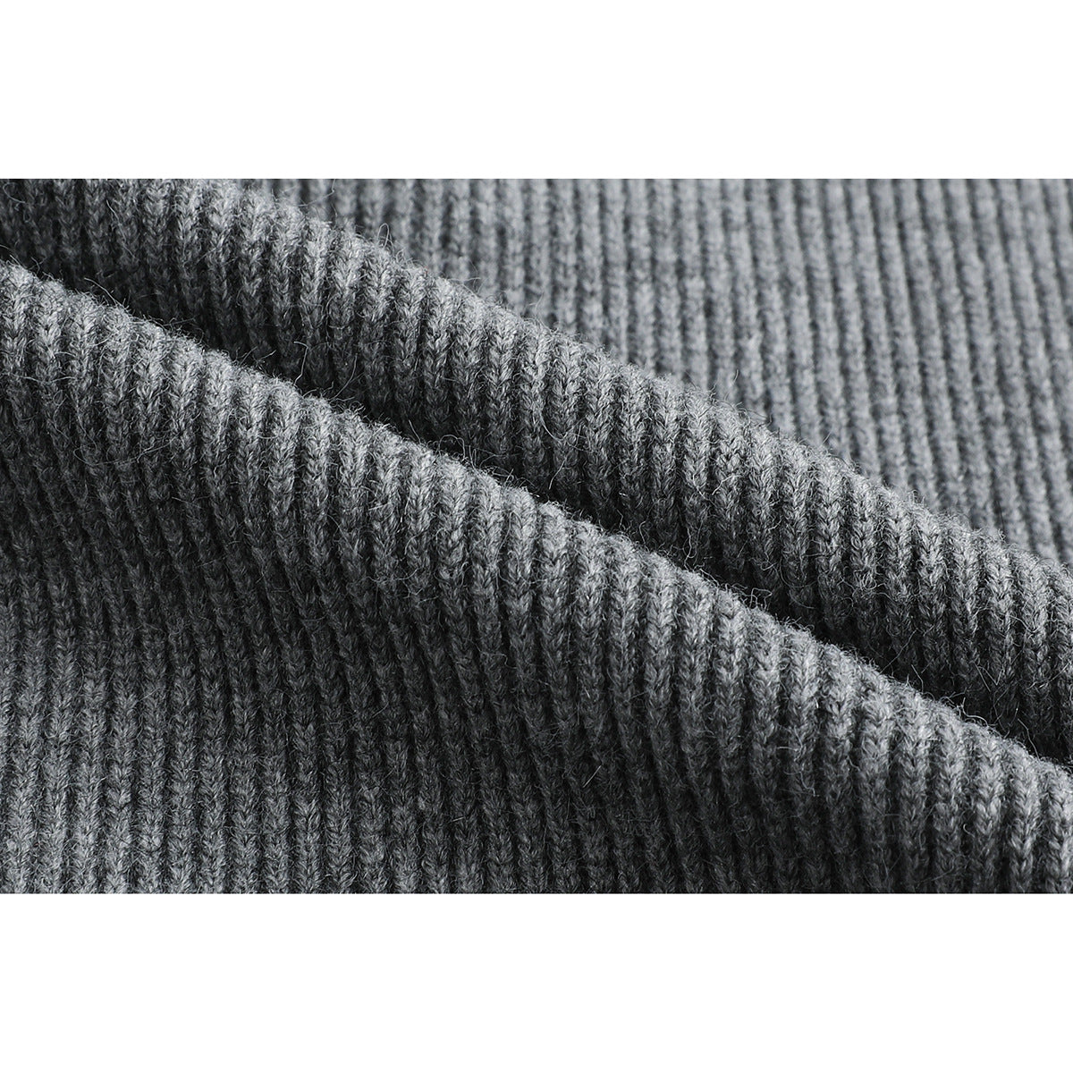 Macro view of the gray sweater's raised ribbed knit texture.