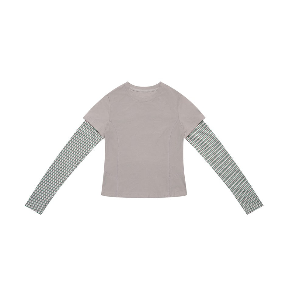 Light gray layered-look top with crew neck, panel seams and green-gray striped long sleeves, flat lay
