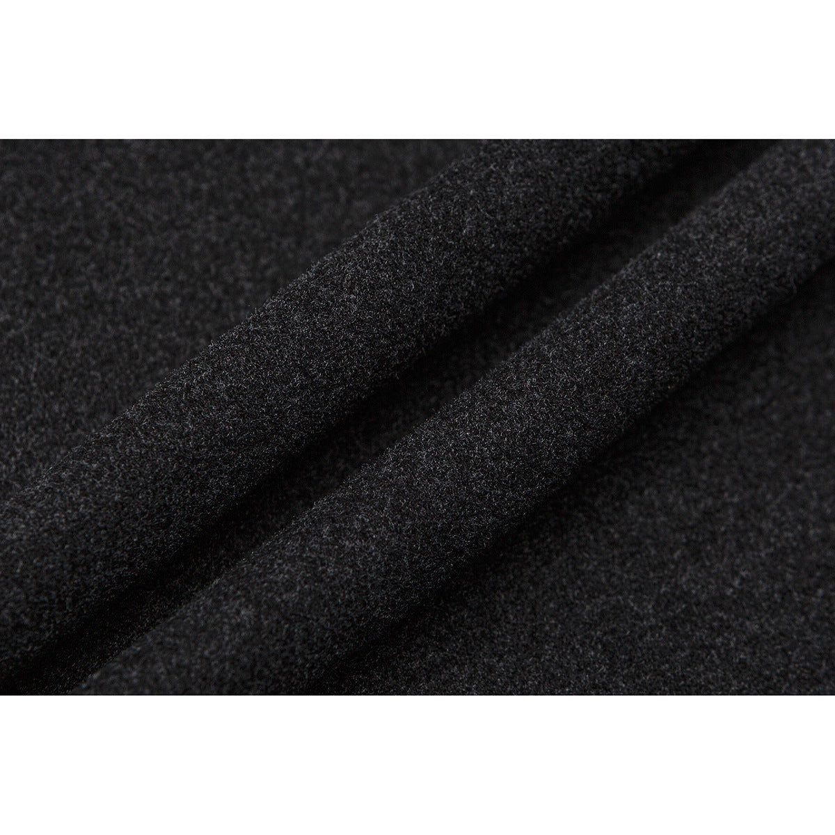 Macro view of charcoal fabric gathered into a diagonal fold.