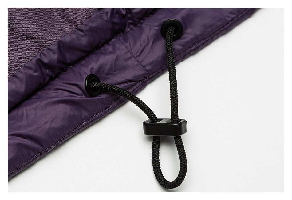 Close-up of a black adjustable drawcord and toggle at the hem of the purple jacket.