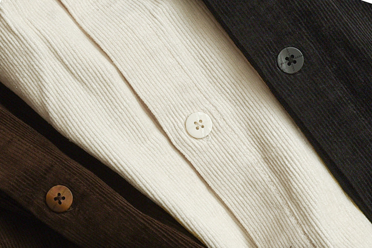 Close-up of cream ribbed fabric with a button, layered over dark charcoal and brown fabric with buttons.
