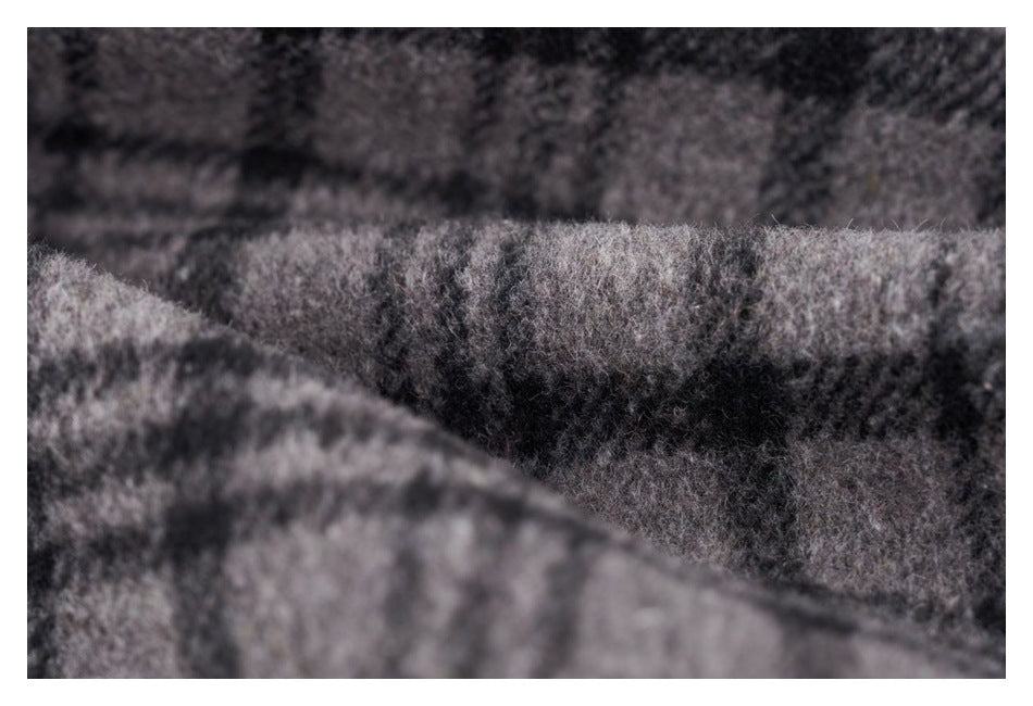 Extreme close-up showing the fuzzy surface and plaid pattern of gray and black fabric.