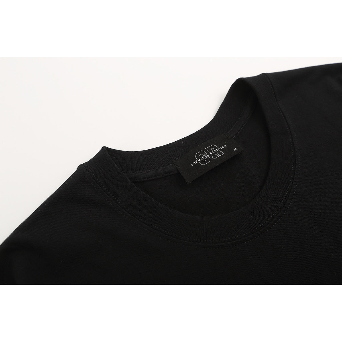 Close-up of a black T-shirt’s crew neck and inner label.