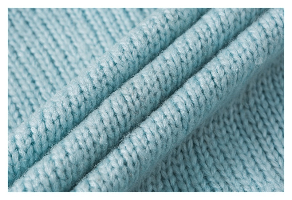 Macro view of thick pale blue knitted fabric and raised ribbed edges.