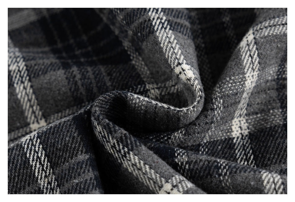 Macro view of the black, gray, and white plaid fabric folded to show its texture and pattern.
