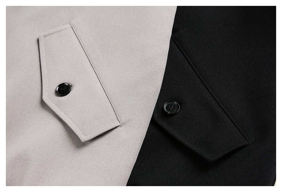 Close-up of light gray and black garment cuffs with buttoned tabs.