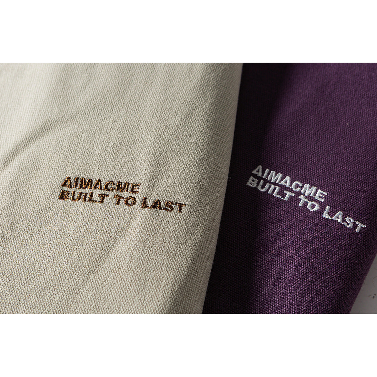 Close-up of embroidered lettering on off-white and purple jacket fabric.