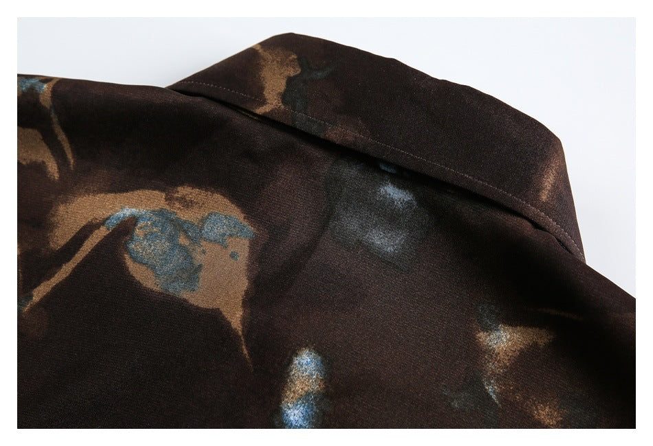 Close-up of the dark brown shirt collar and abstract blue and tan print.