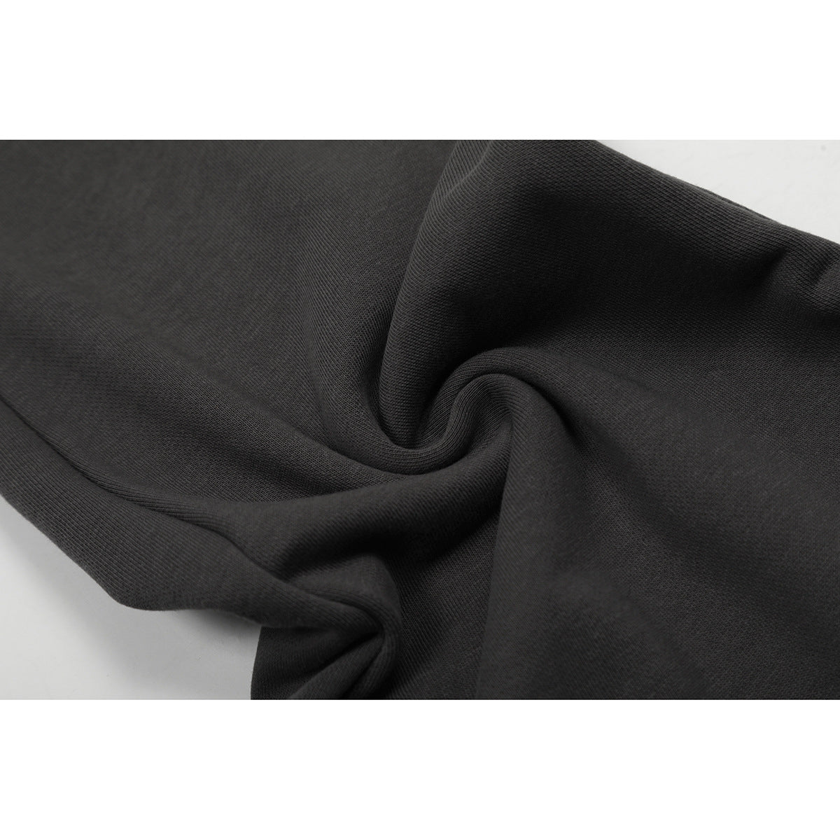 Close-up of charcoal fabric draped to show its knit texture.