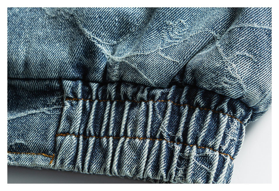 Close-up of gathered blue denim with orange stitching and a folded seam.