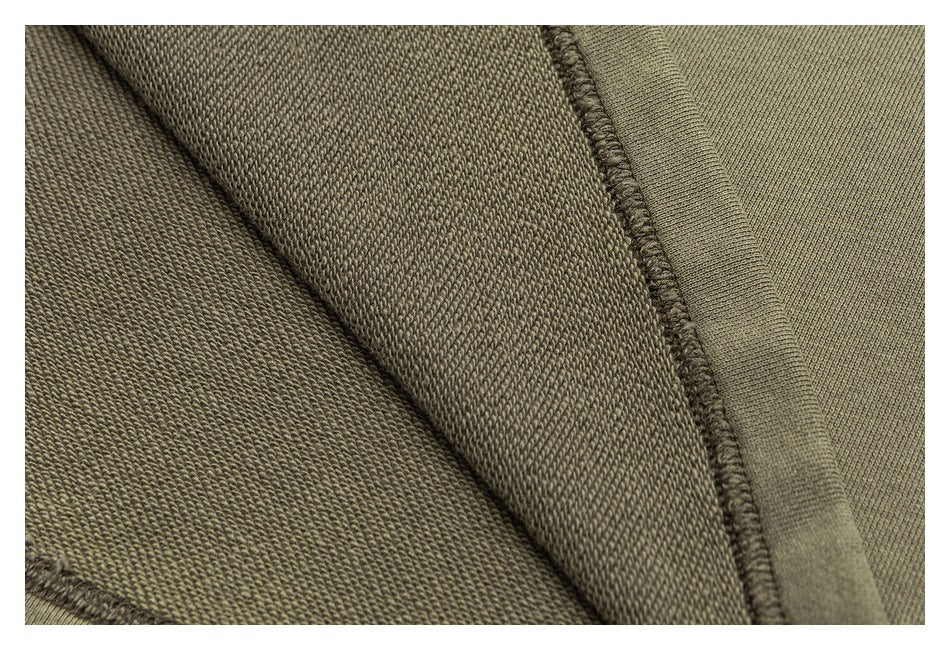 Close-up of olive sweatshirt fabric layers and an overlocked seam.