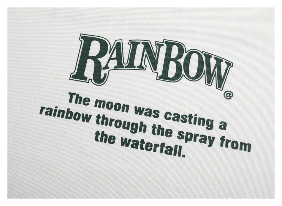 Close-up of dark green “RAINBOW” lettering and an English sentence printed on white fabric.