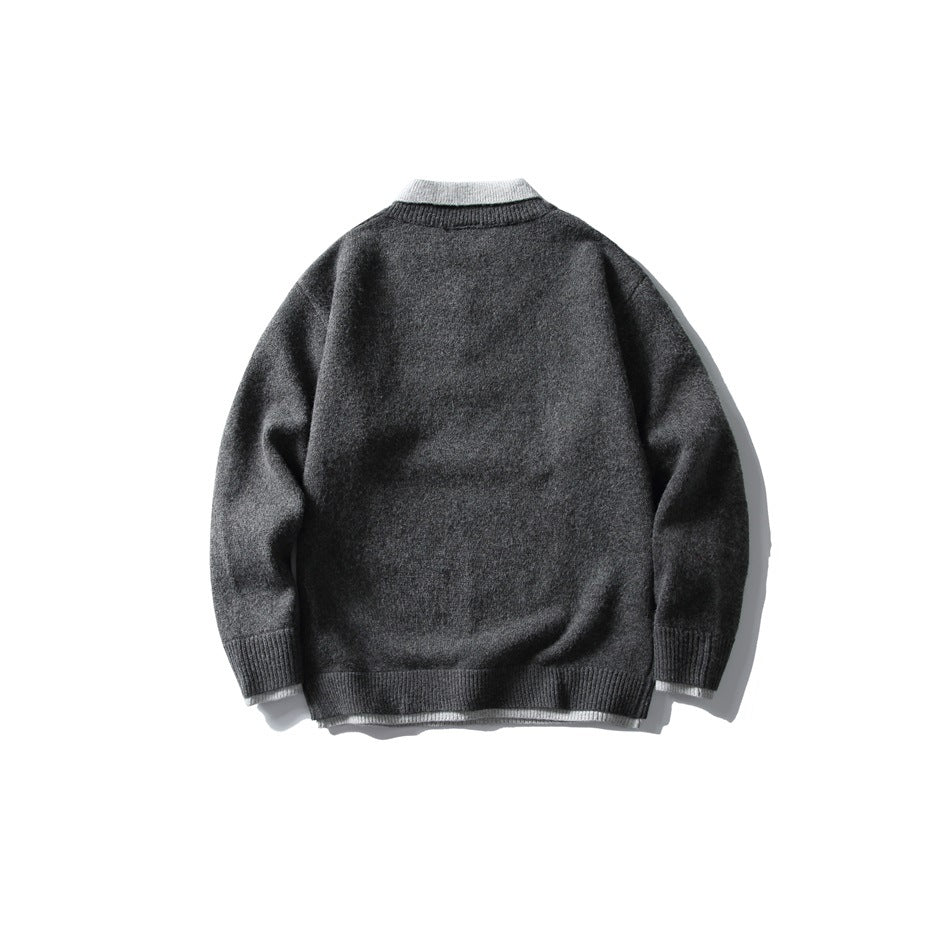 Back view of a charcoal knit sweater with a light contrasting collar and ribbed cuffs and hem.
