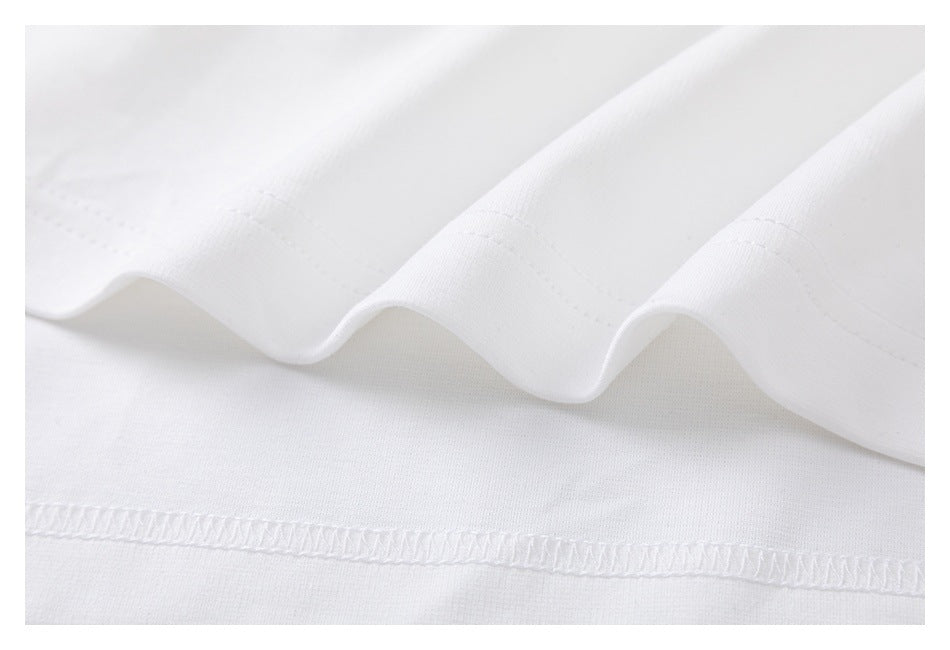 Close-up of a white garment's folded hem and overlock stitching.
