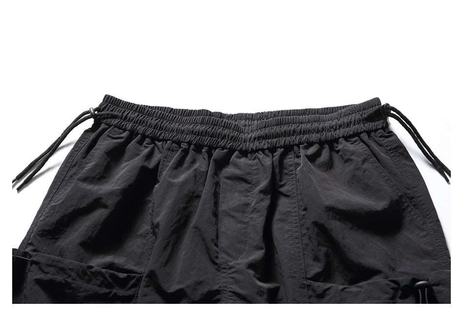 Close-up of the black shorts' elastic waistband, drawstrings, and upper front pockets.