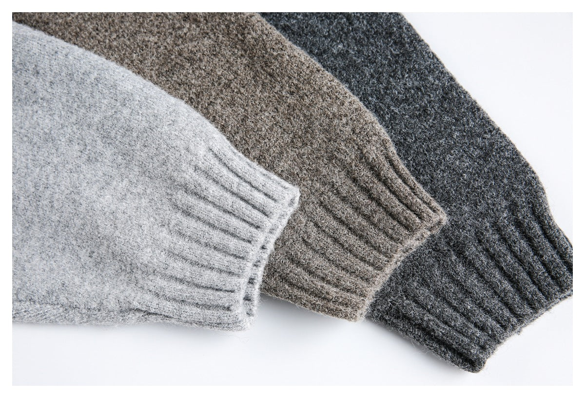 Close-up of ribbed sweater cuffs in light gray, brown, and charcoal knit.