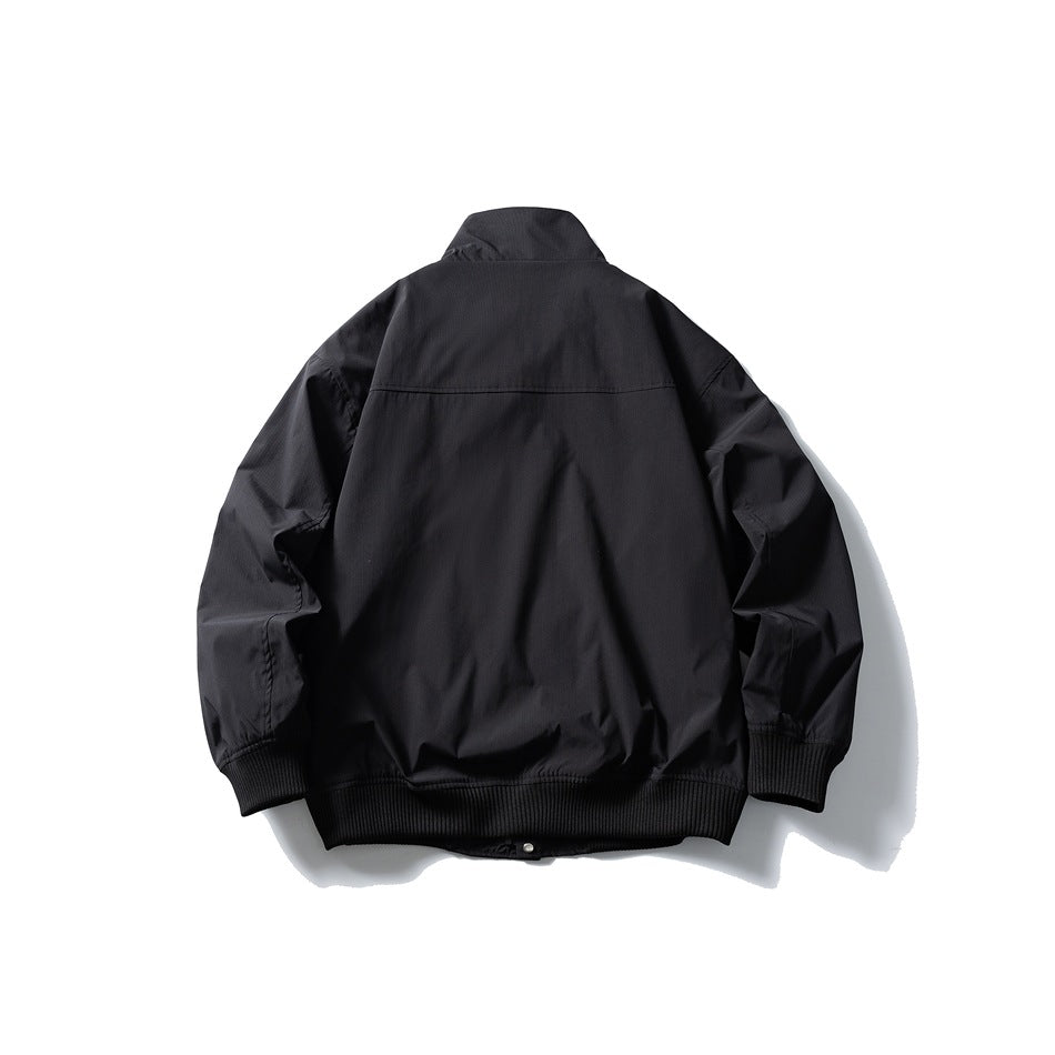 Black stand-collar jacket flat lay back view showing back yoke seam and ribbed cuffs and hem