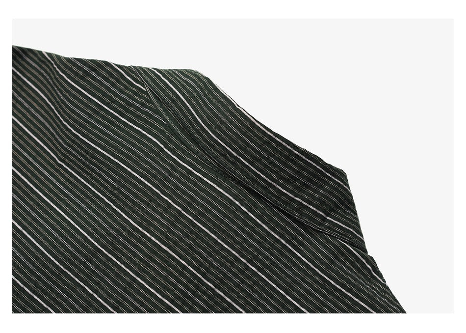 Close-up of a folded dark garment showing narrow white diagonal stripes and a stitched edge.