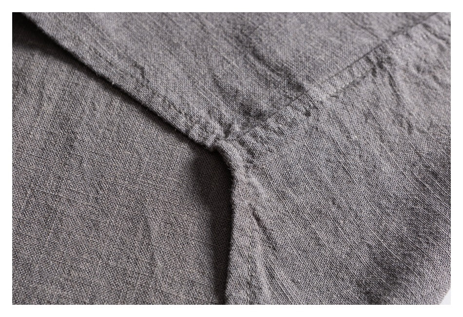 Close-up of stitching and a seam on gray shirt fabric.