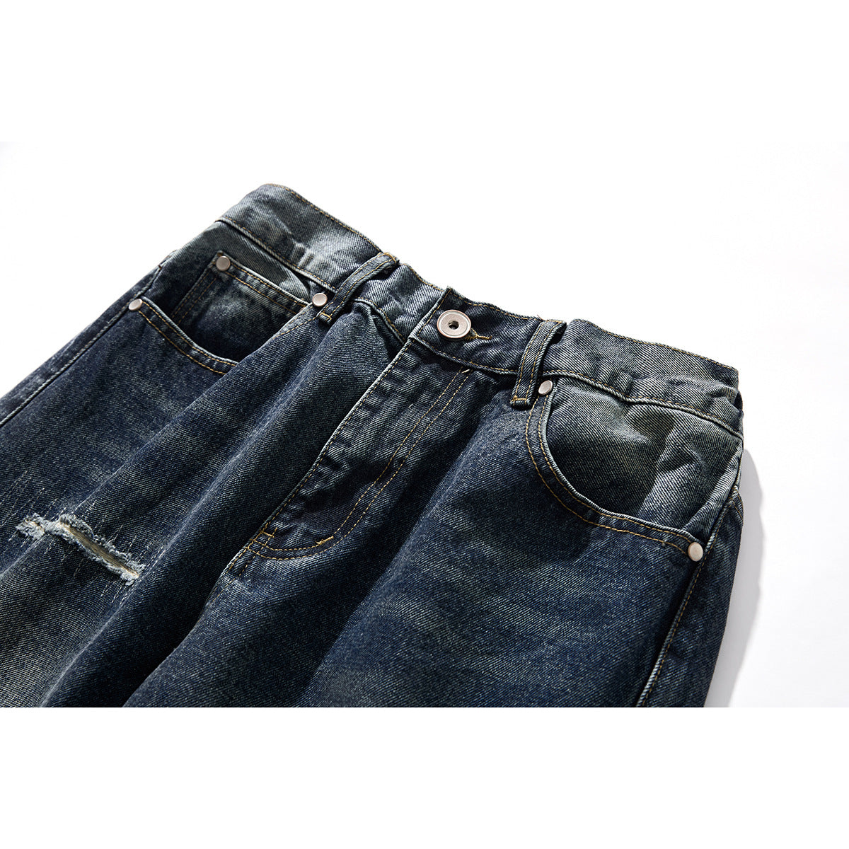 Close-up of dark washed blue jeans showing the front waistband, button, pockets, belt loops and distressed detail.