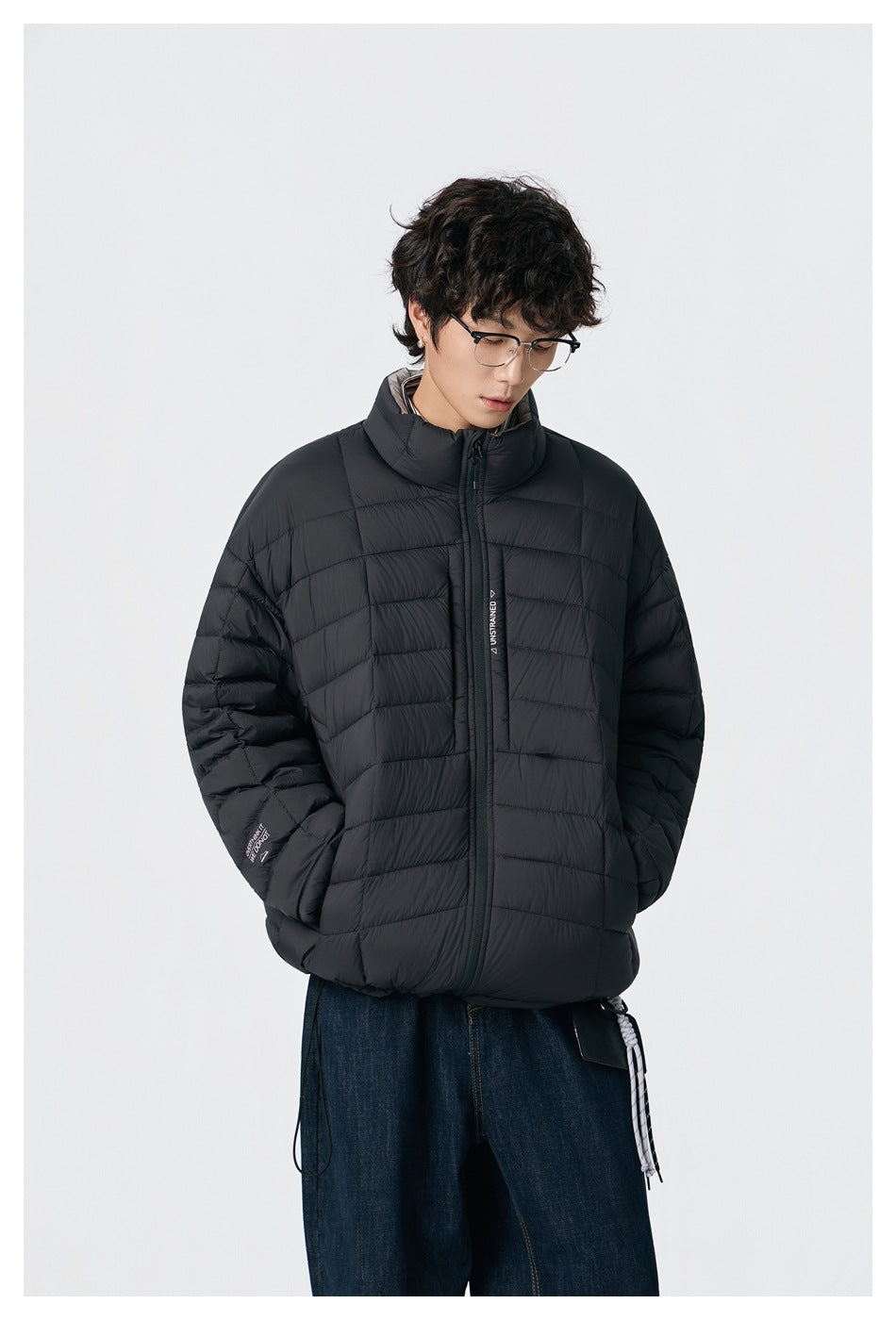 Model wearing the black quilted stand-collar jacket over dark jeans, front view