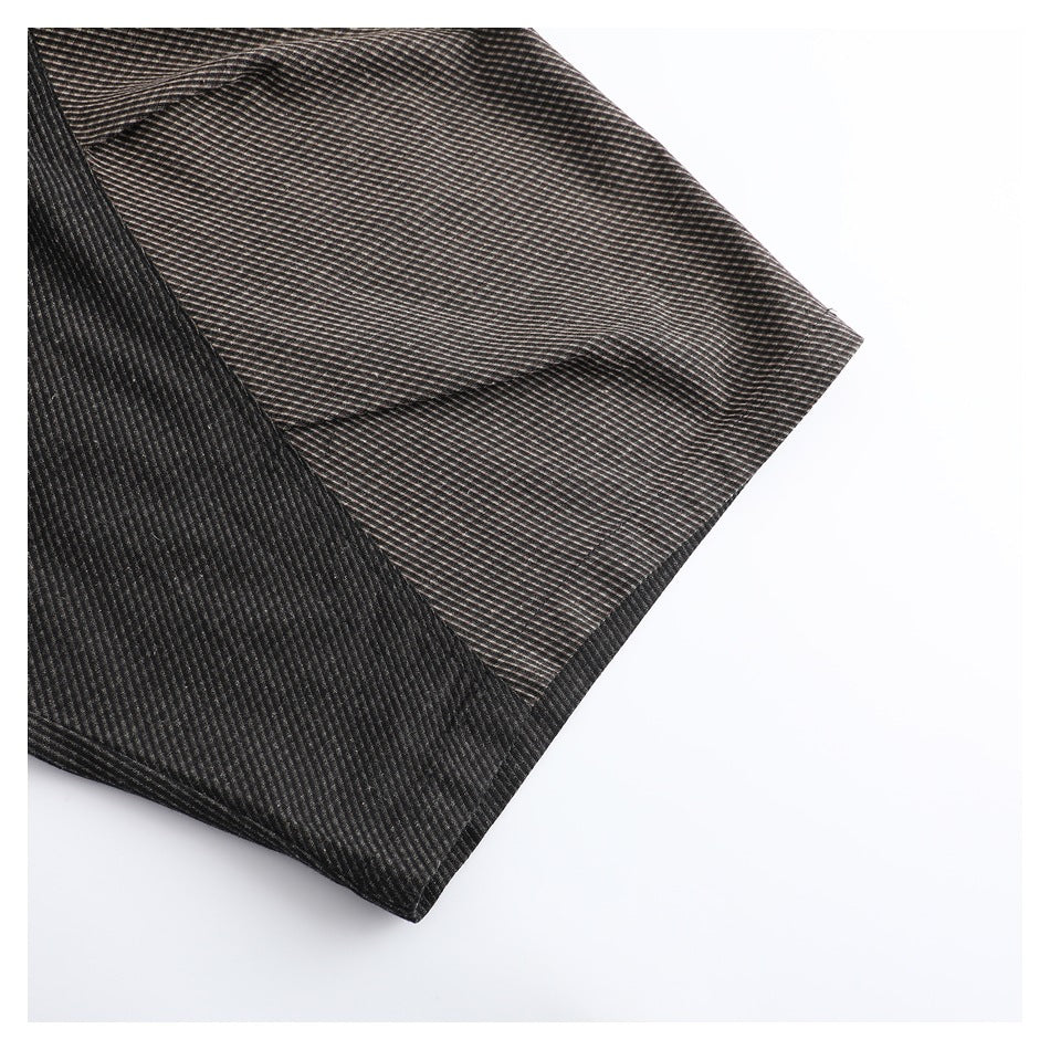 Close-up of a dark brown and black finely striped garment edge with a folded seam.