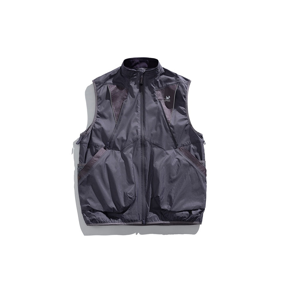 Front view of a dark charcoal zip-front utility vest with large pockets and contrasting panels.