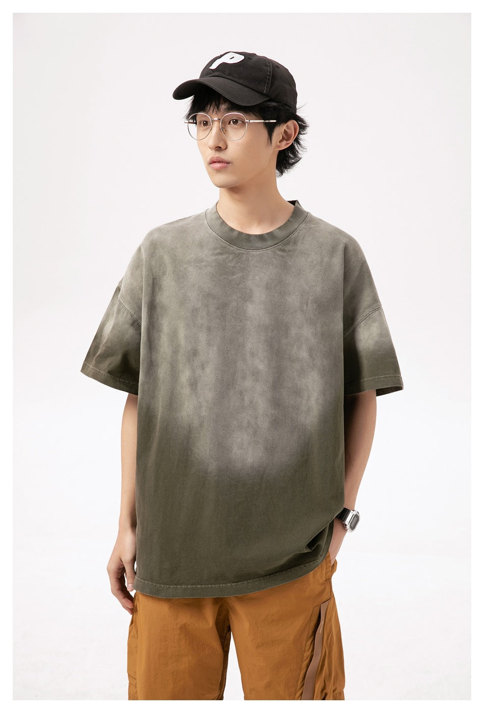 Closer front view of a model wearing an oversized mottled olive-gray short-sleeve T-shirt.