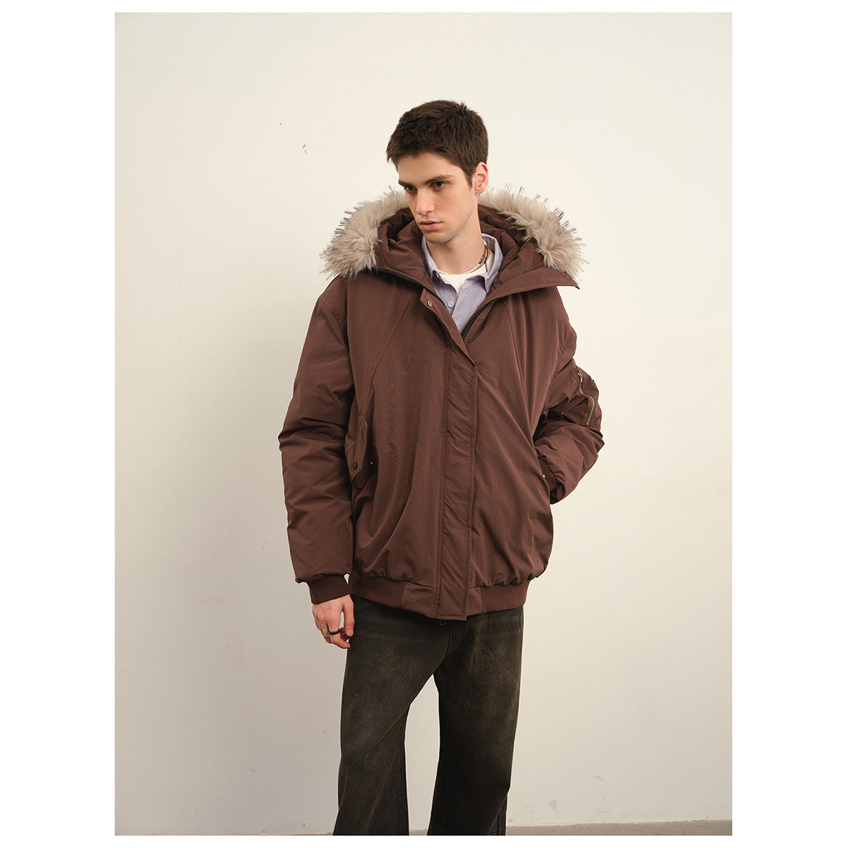 Man wearing a dark brown hooded jacket with light fur trim, front view.