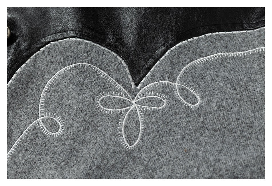 Close-up of white loop embroidery across a gray jacket panel beneath a black section.