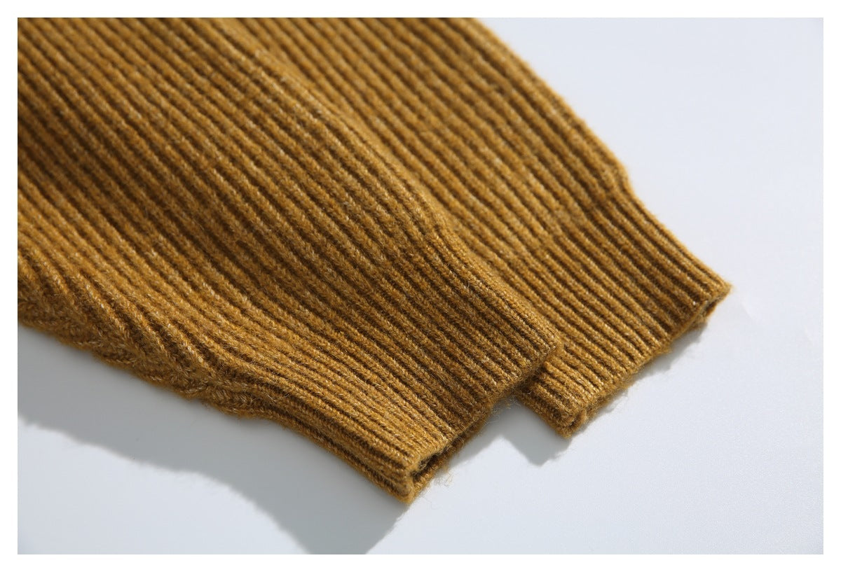 Close-up of the ribbed cuff at the end of a mustard-brown cardigan sleeve.