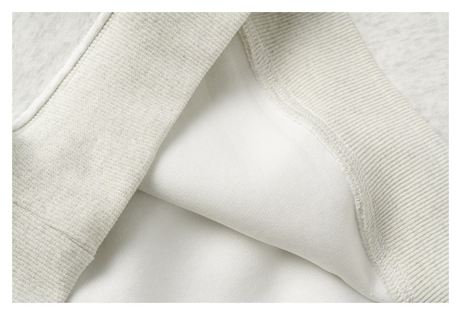 Close-up of the sweatshirt's inner fabric, overlocked seam, and ribbed cuff or hem trim.