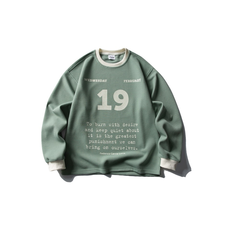Green waffle-knit crew neck sweatshirt with cream collar and cuffs and a large 19 date print with quote