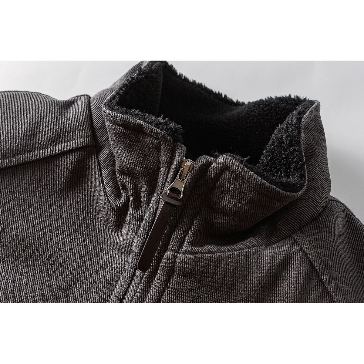 Close-up of a charcoal jacket collar with black fleece lining and a front zipper.