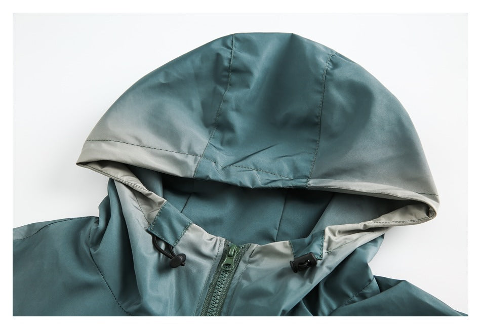 Close-up of a teal jacket hood with light gray lining, drawcord toggles, and a front zipper.