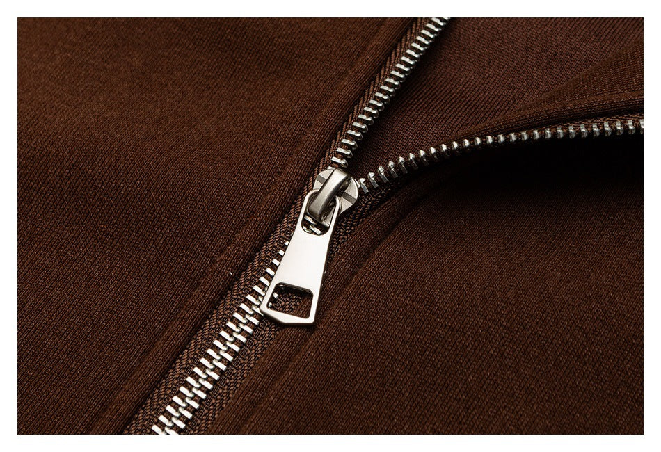 Close-up of a silver metal zipper against dark brown fabric.
